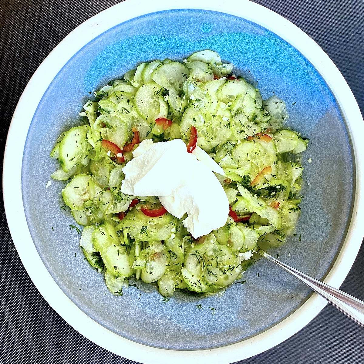Cucumber salad served with yogurt and red peppers