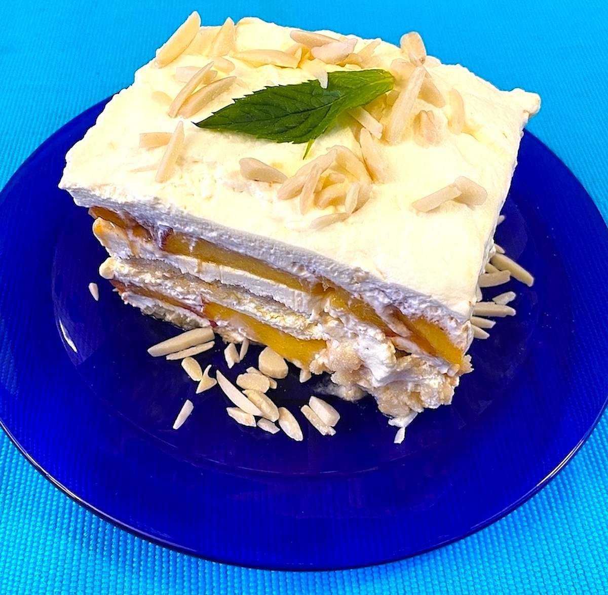 Serving od peach tiramisu with mint leaf on top