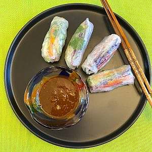Four spring rolls on black plate