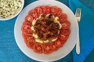 Gnocchi serving surrounded by tomato slices