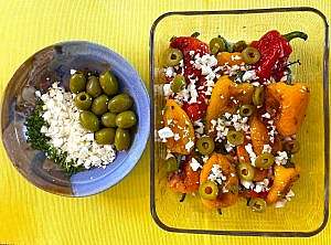 A fork lifting a blistered mini pepper from the finished Mediterranean salad.