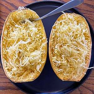 Roasted spaghetti squash halves with golden strands ready to be scraped